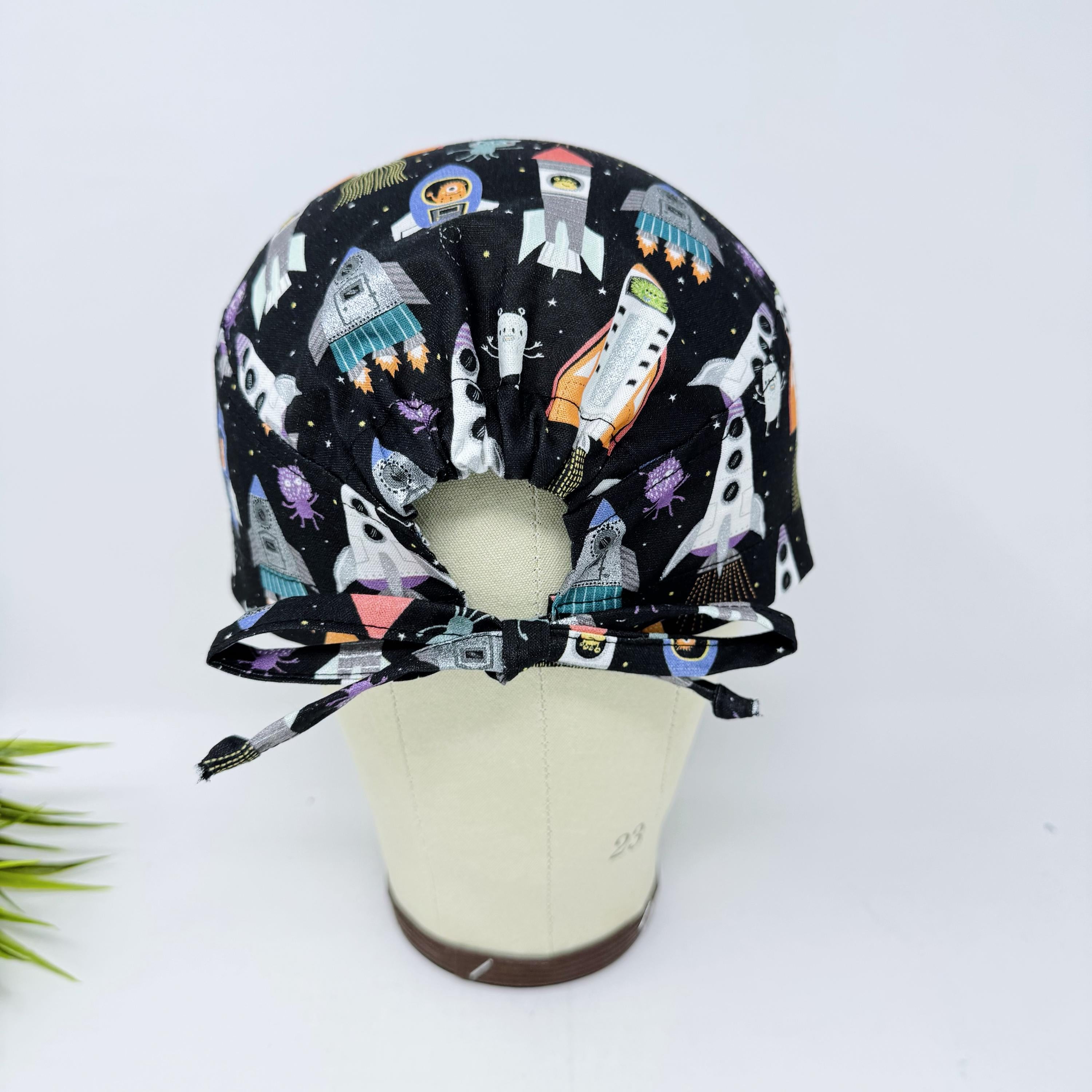 Men's surgical scrub cap. Black Space Rocket Print skull tie-back style scrub hat by Paradise Caps.