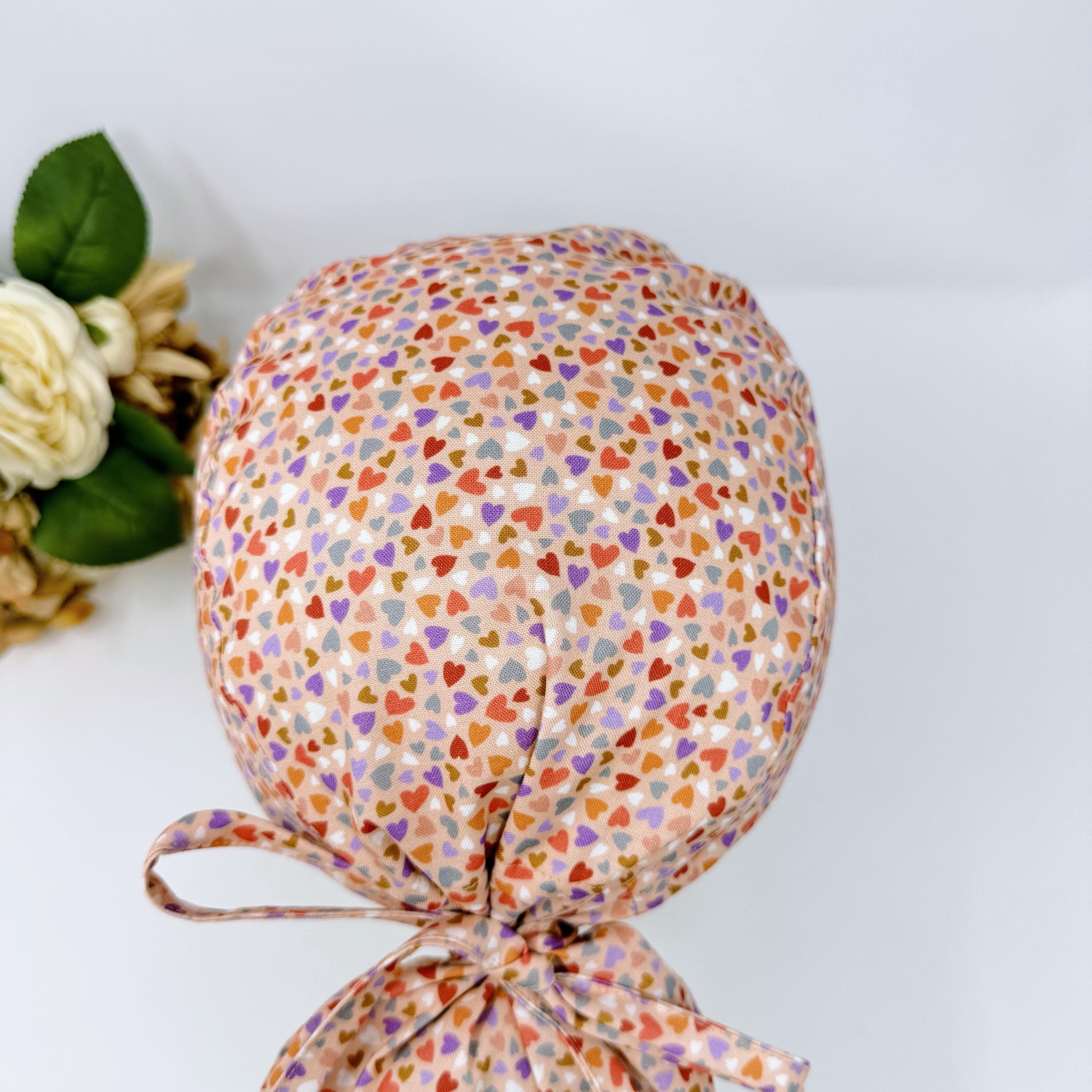 Colorful Hearts Ponytail scrub cap with satin lined. Pink surgical cap for women by Paradise Caps.