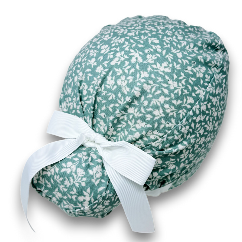 Mint-green Euro Plus scrub cap with tiny white flowers and pale ribbon ties