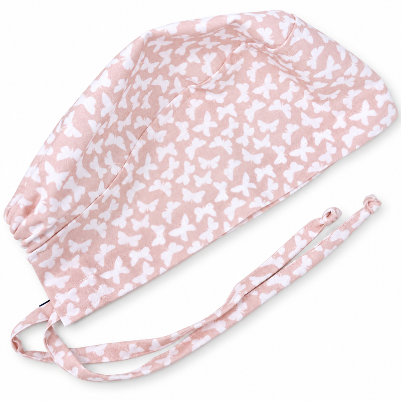 Blush Butterflies Surgical scrub cap. Butterfly Skull tie-back style scrub hat by Paradise Caps. on white background with soft shadow