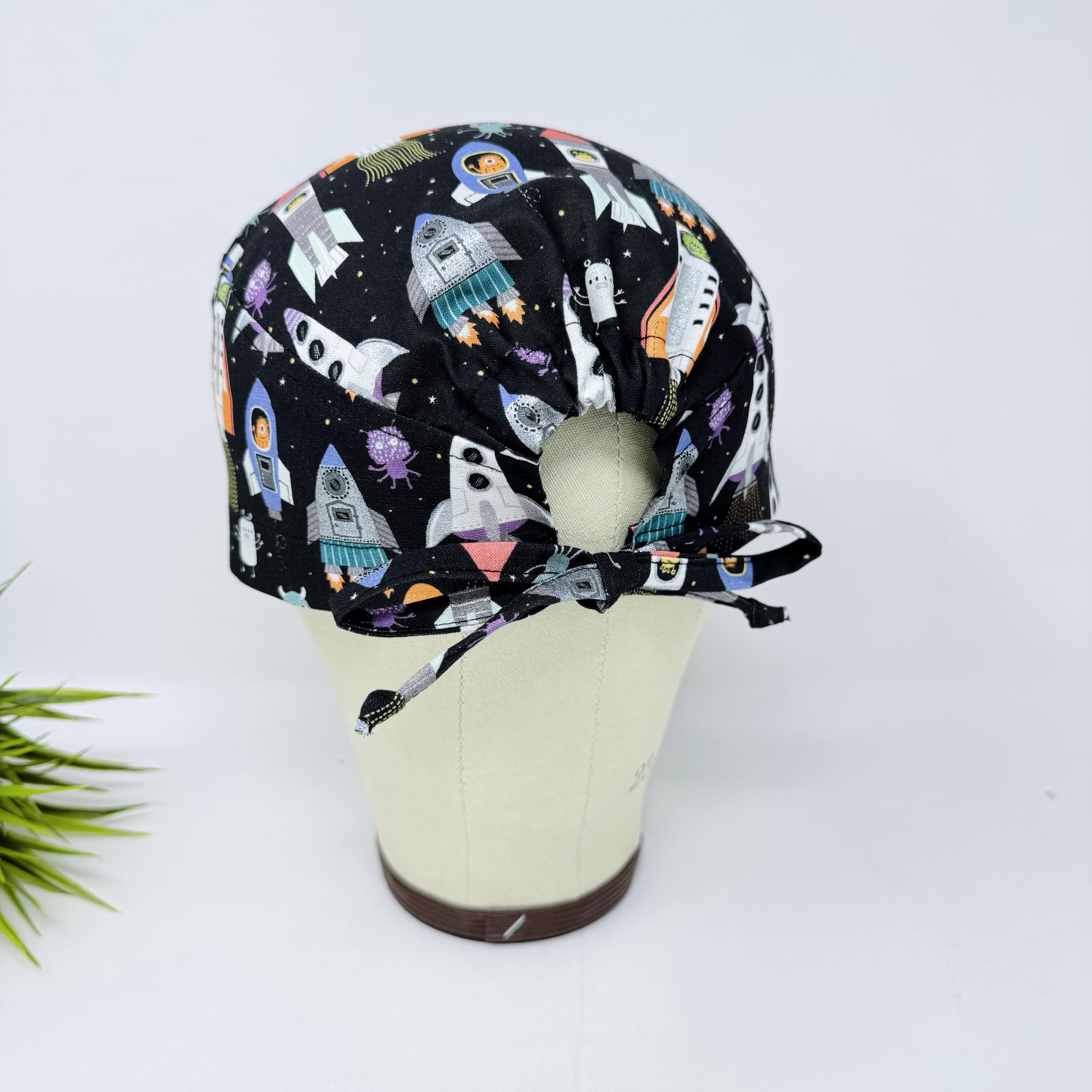 Men's surgical scrub cap. Black Space Rocket Print skull tie-back style scrub hat by Paradise Caps.