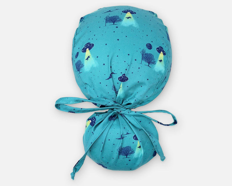 Teal cotton ponytail scrub cap with UFOs, yellow beams and trees, shown from above with a full hair pouch and matching fabric ties.