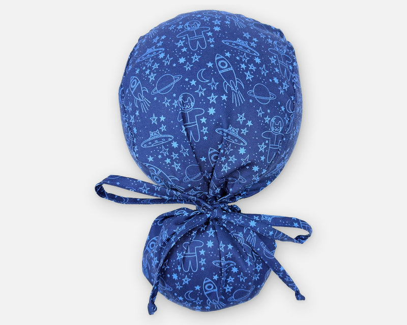 Blue cotton ponytail scrub cap with space cats, rockets and stars, shown from above with a full hair pouch and matching fabric ties.