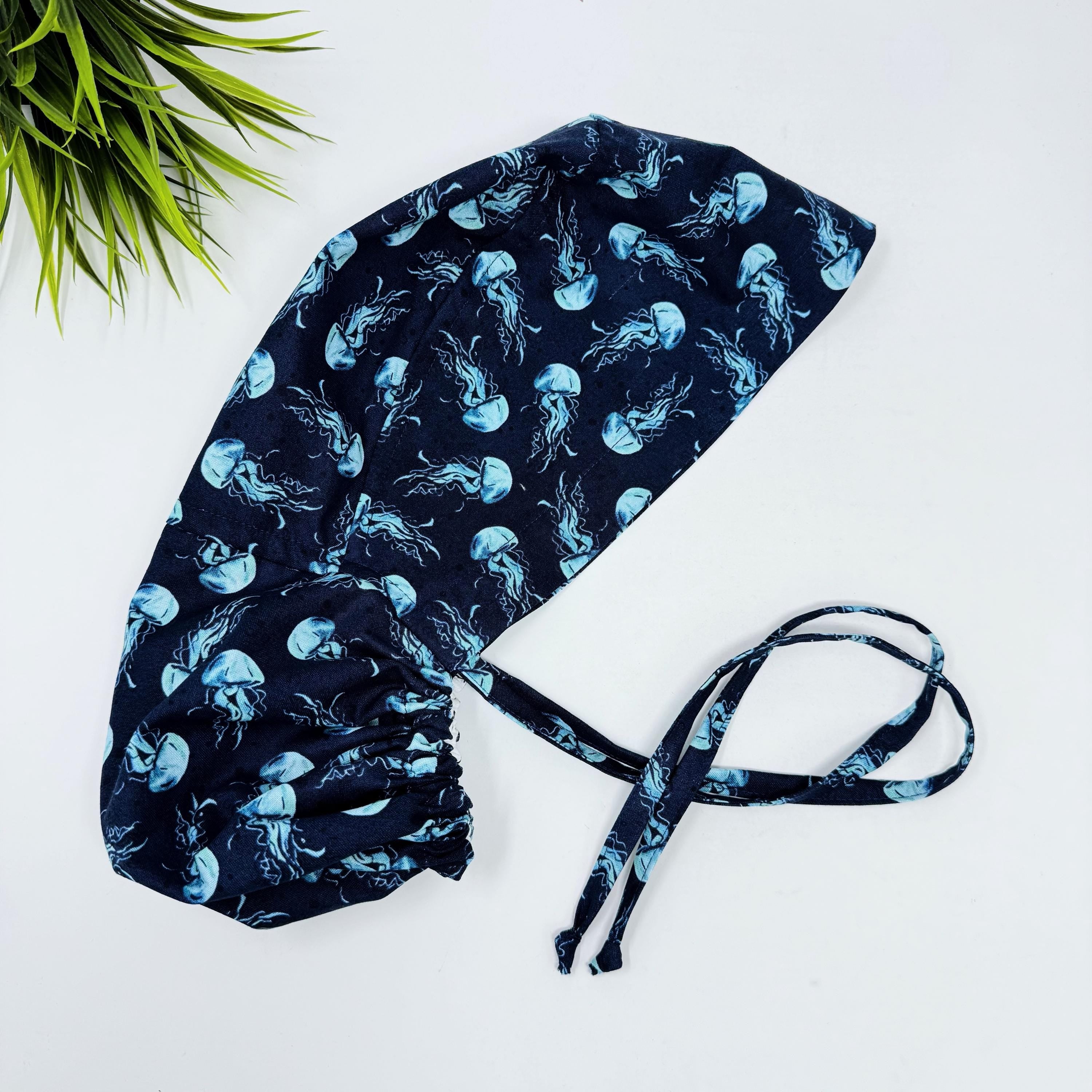 Jellyfish ponytail scrub cap women. Navy Blue Ocean Print Satin Lined option Ponytail scrub hat. Scrub caps for women by Paradise Caps.