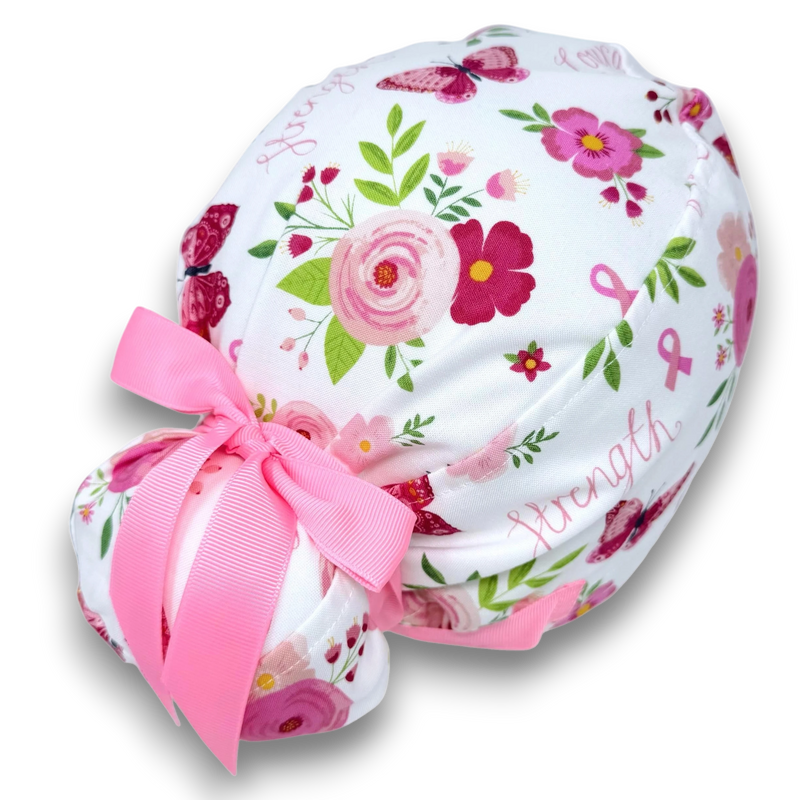 Paradise Caps white Euro scrub cap with pink floral, butterfly, and breast cancer ribbon print. Features ties and satin lining.